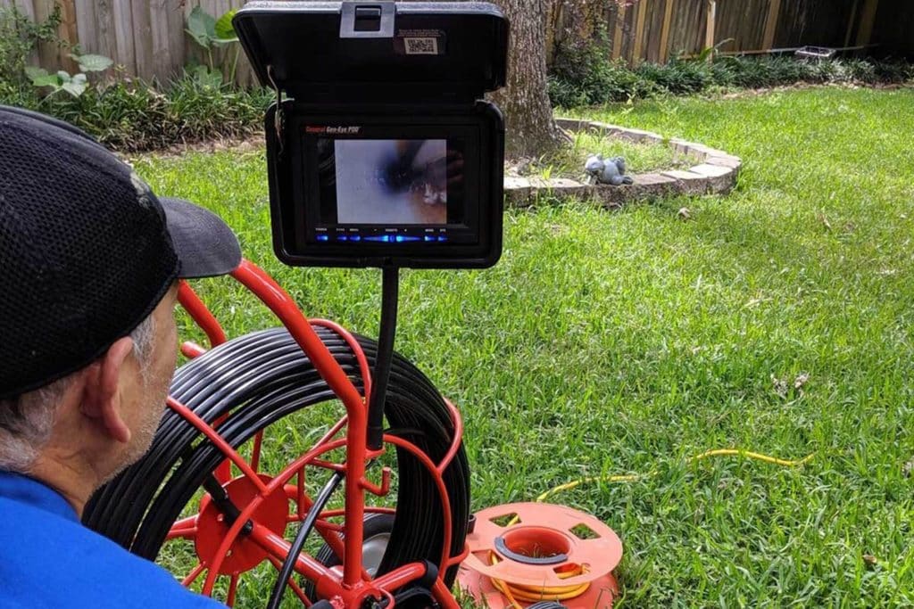 Plumber running a sewer camera inspection from an outdoor cleanout to find the cause of a sewer backup in Jurupa Valley, CA